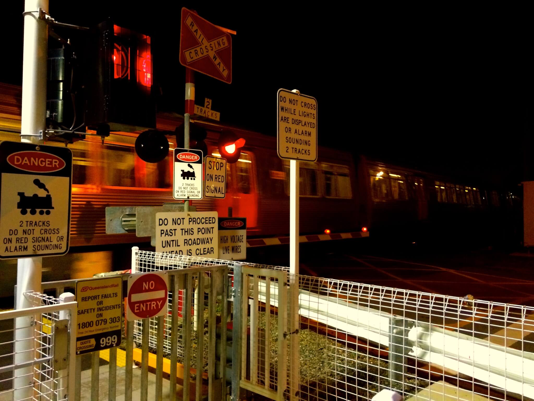 A level crossing in Queensland with many signs.