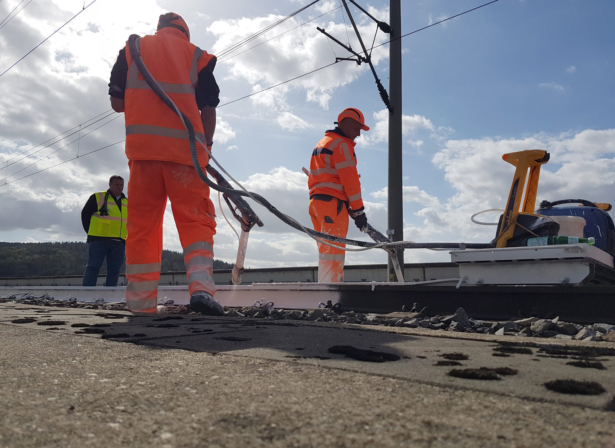 DB employees painting rails white