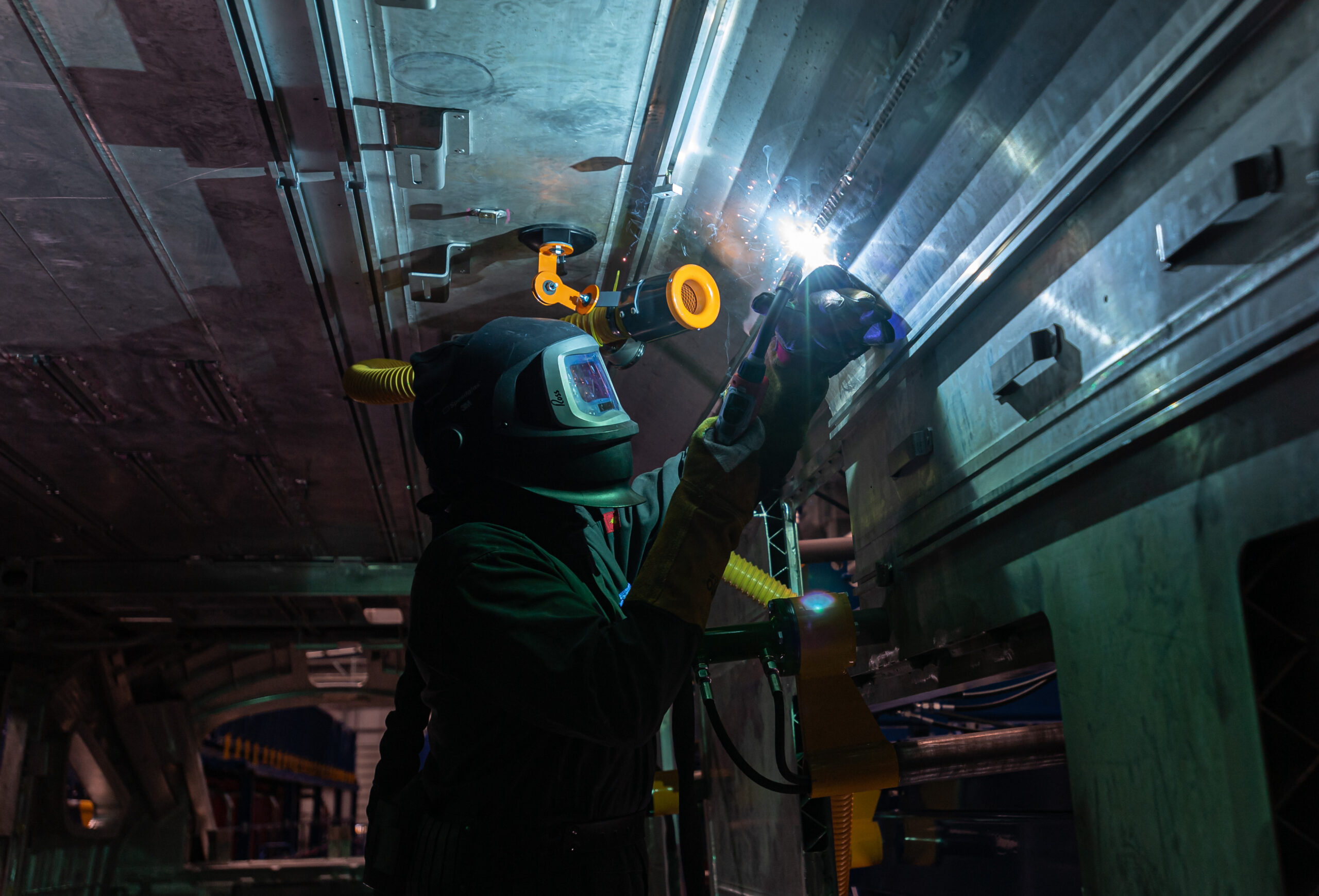 A welder manually working on a train shell at the Weld Workshop, Hitachi Rail, Newton Aycliffe