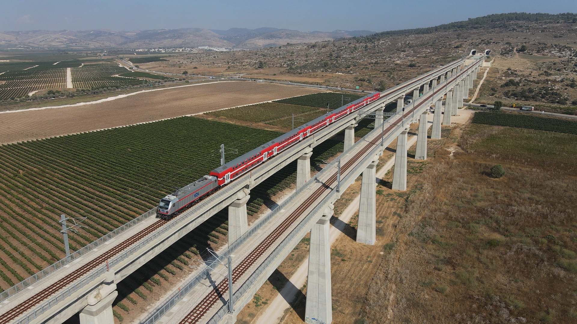 Train comprising TRAXX P160 AC3 locomotive and Twindexx Vario coaches passes the Ayalon Valley in Israel