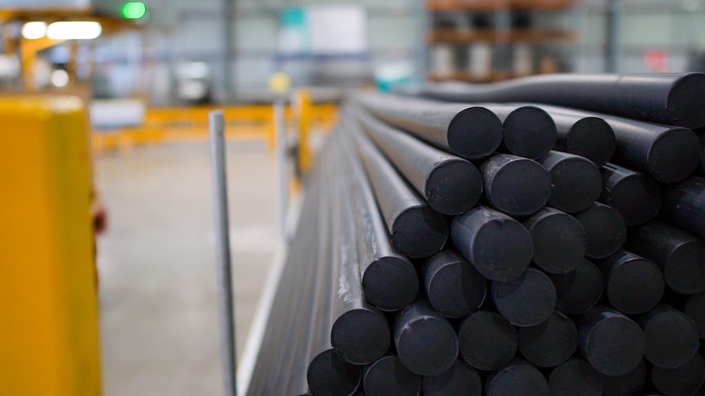 Long cylindrical rubber tubes laying flat in warehouse