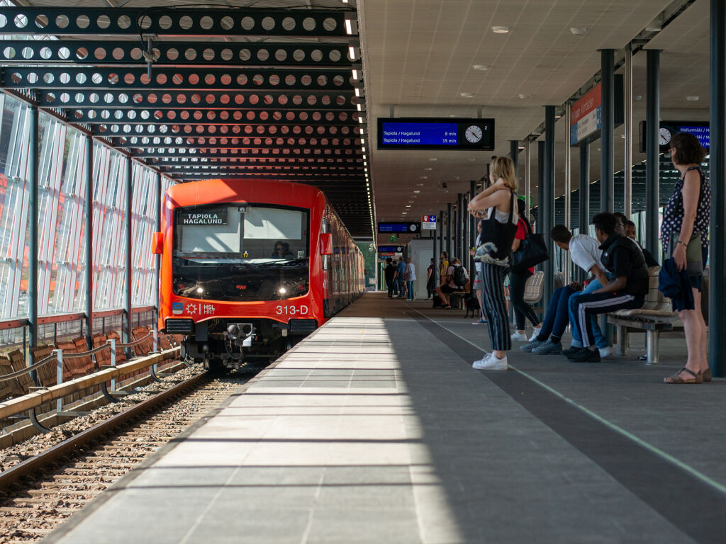 An image showing passengers waiting for a train as it arrives at a station