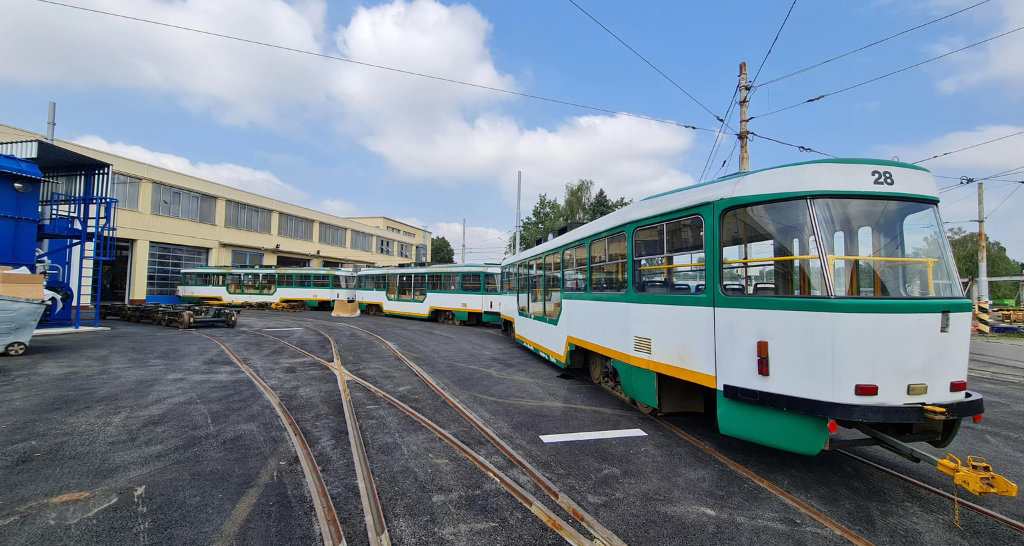 A newly refurbished white, yellow and teal tram