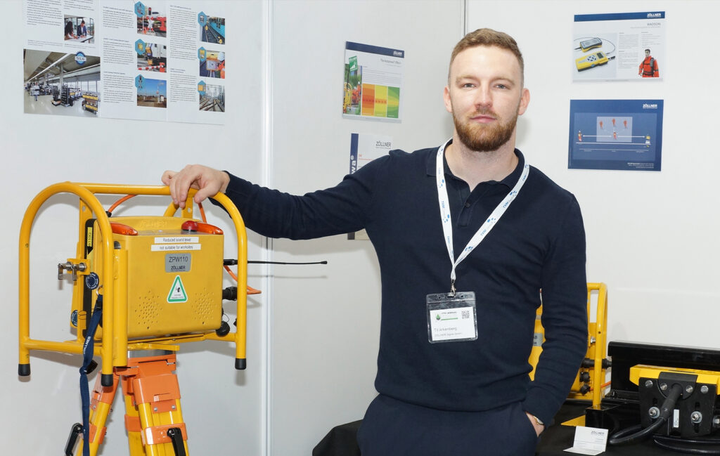 Zollner employee standing next to their mobile track safety system