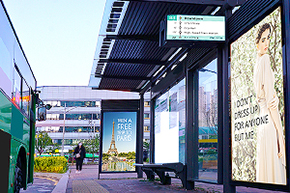 Screens at a bus stop showing information for prospective waiting passengers