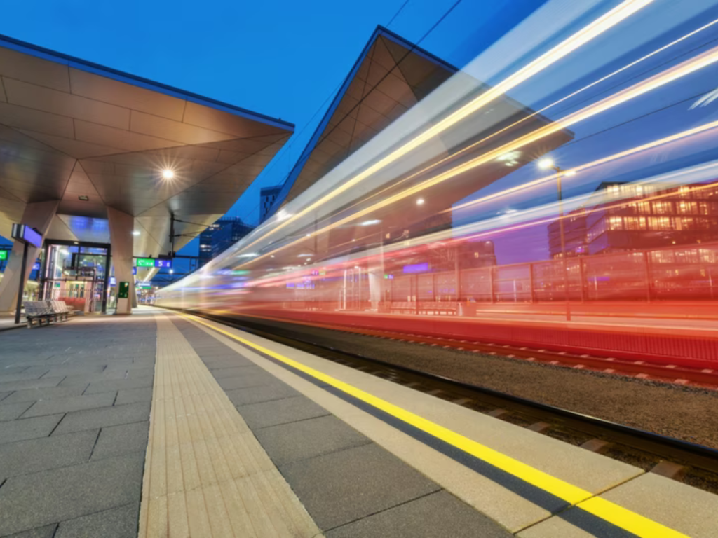 An image of a train speeding through a station imperceivably quickly