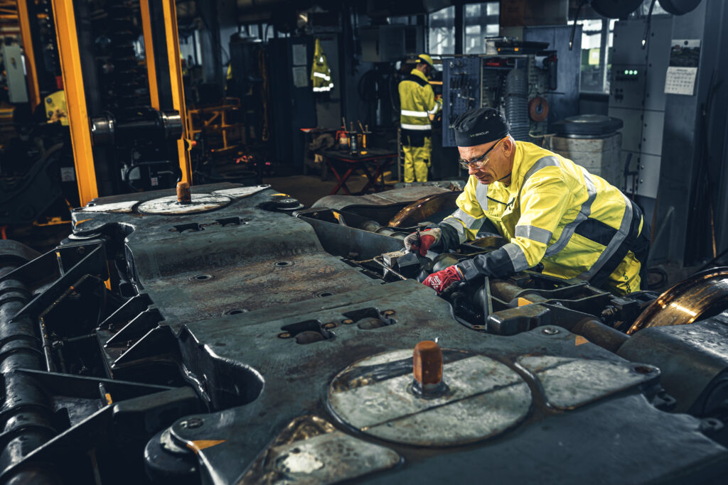 A worker in high-vis doing maintenance on a bogie