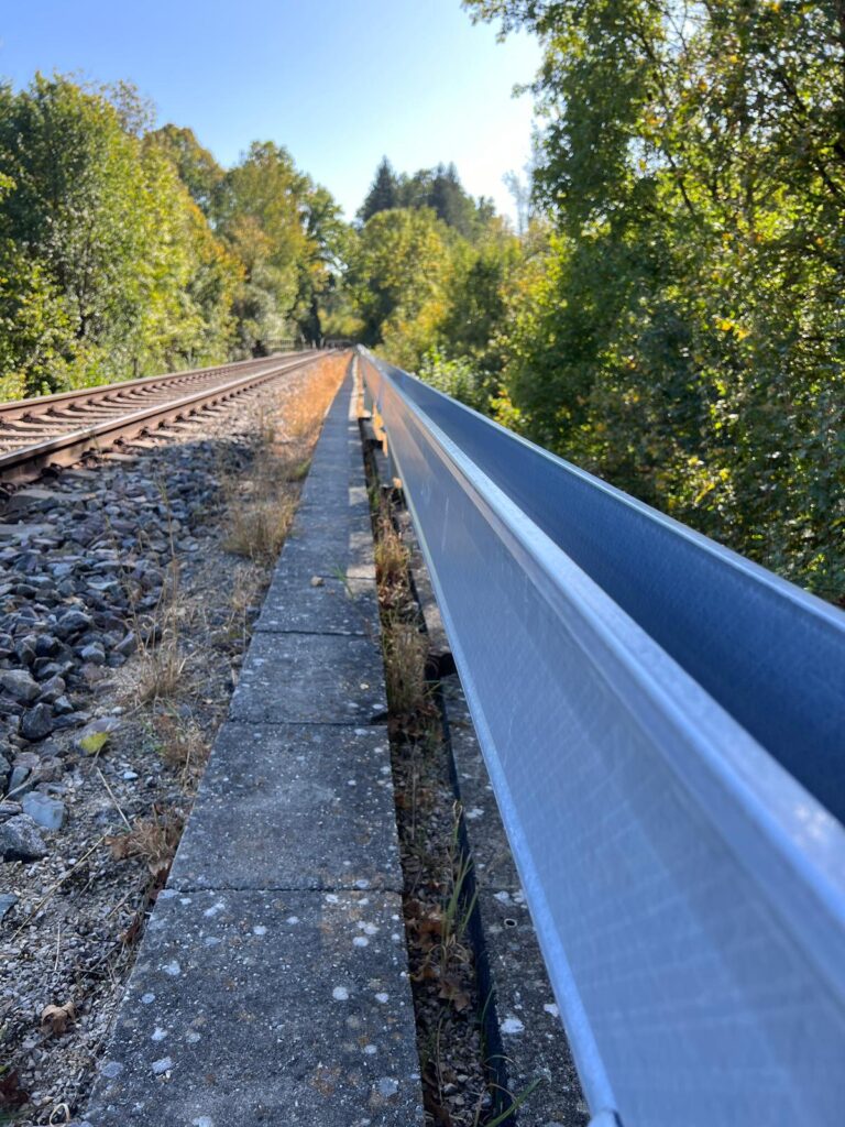 Train tracks leading to a lush woodland. The CCS Arcosystem runs alongside the tracks