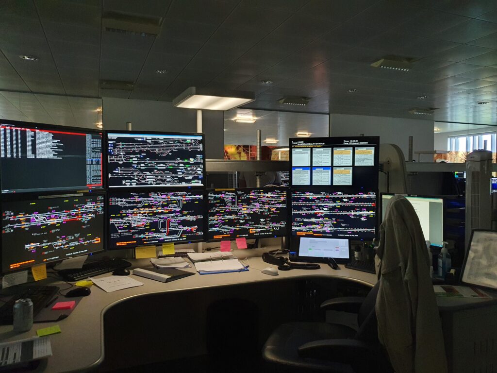 7 computer monitors showing an intricate train map