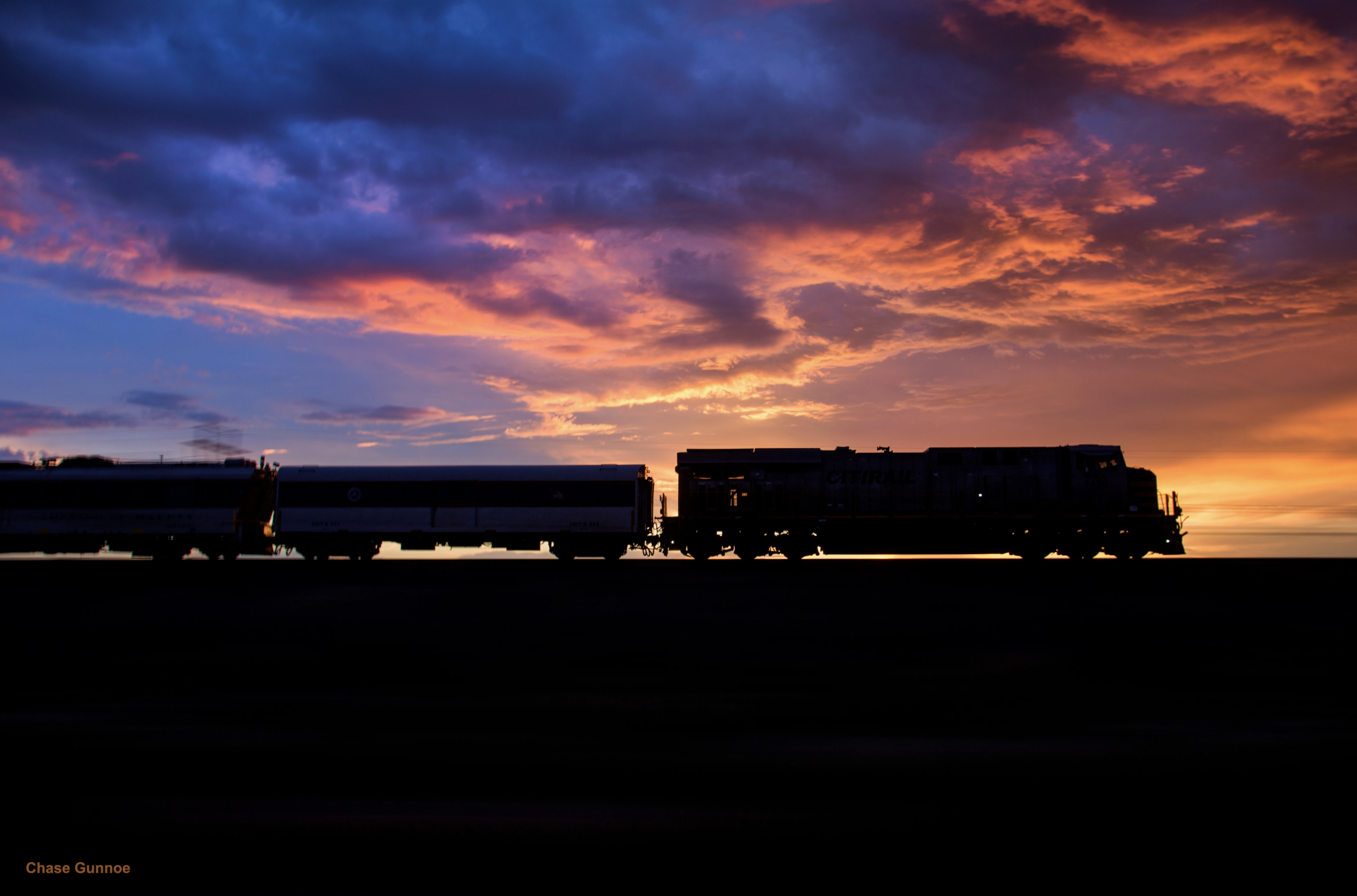 Silhouette of a cargo train in front of the sunset