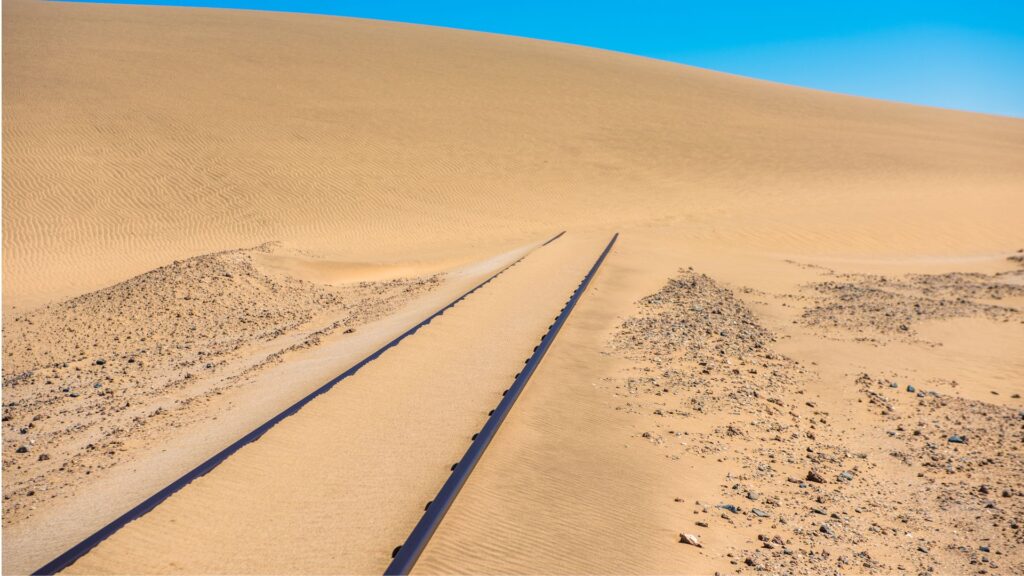 A railway engulfed by sand blown in the wind