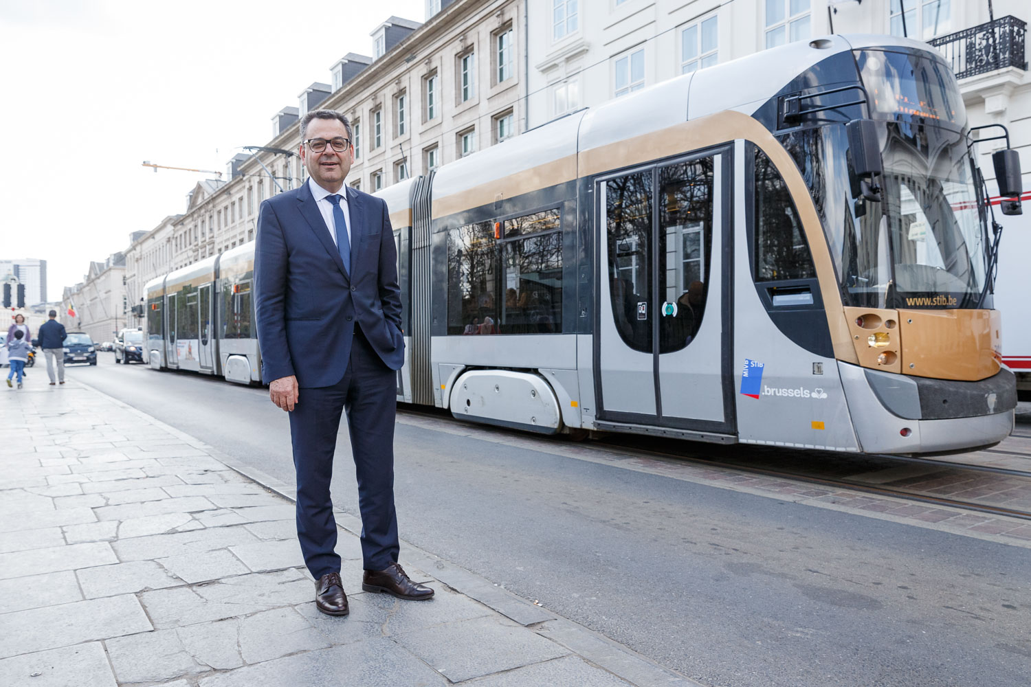 Mohamed Mezghani standing on the pavement beside a white tram