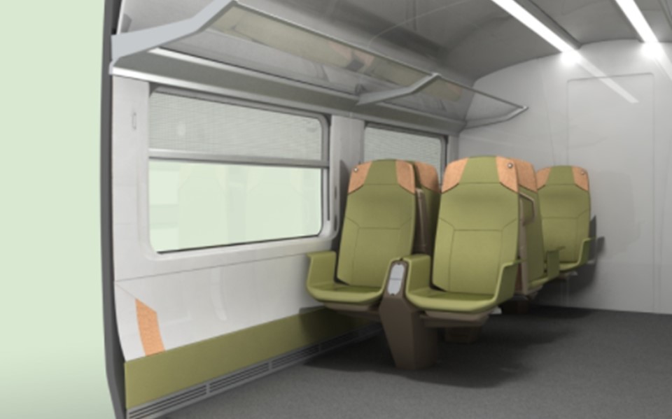 The interior of a modern train carriage features light green and beige seating arranged in rows facing forward, with large windows providing natural light, and overhead racks for luggage.