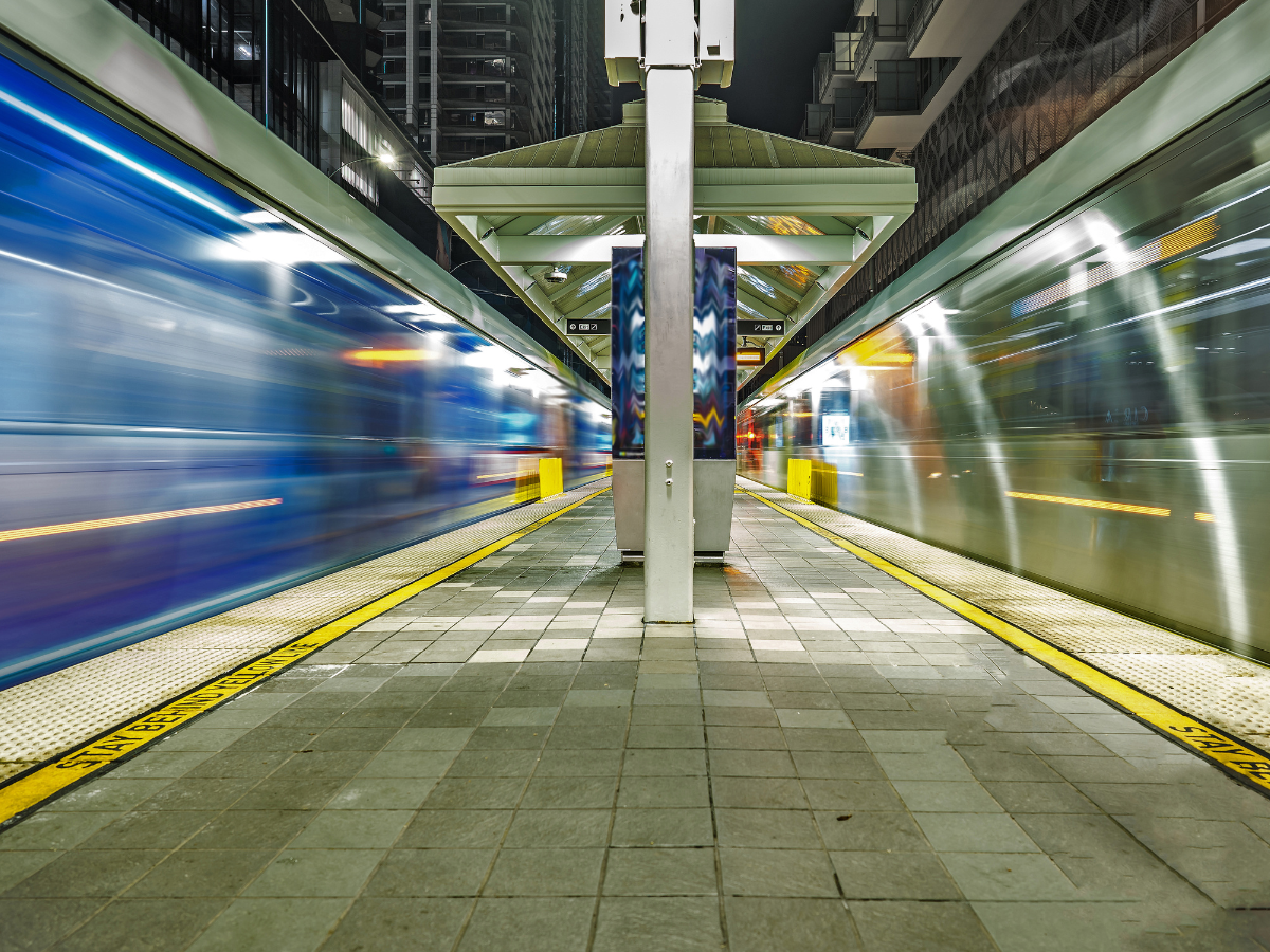 Two LA Metro trains speeding through a station