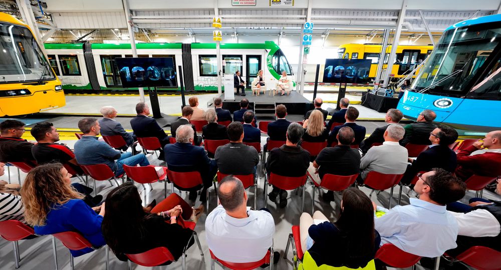 A group of people sat watching a presentation