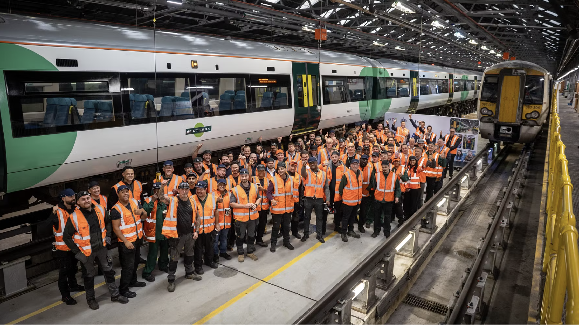 A team of engineers celebrating by a Southern train