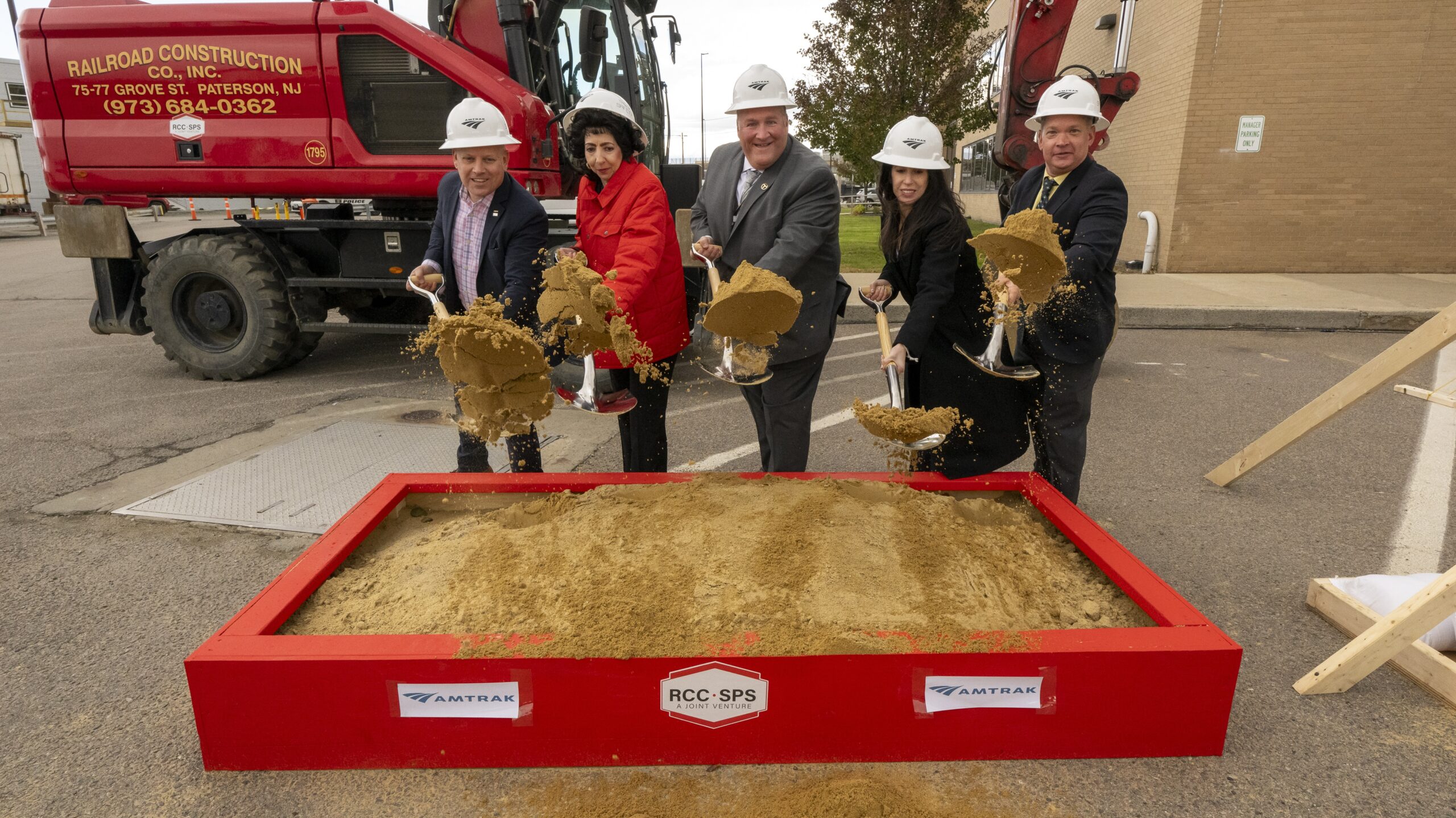 A set of people breaking ground in a small box