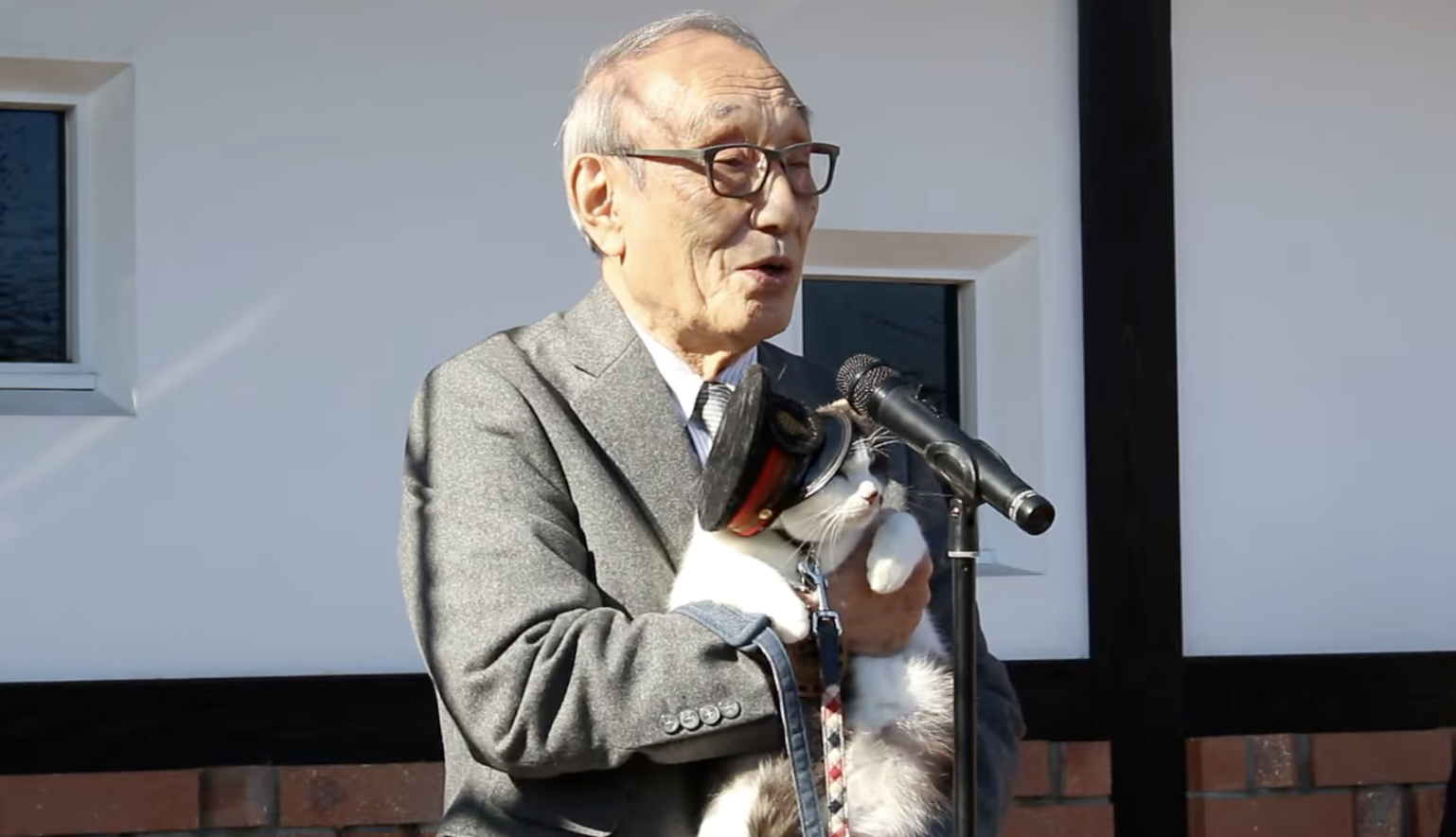 A man holding a cat in a hat