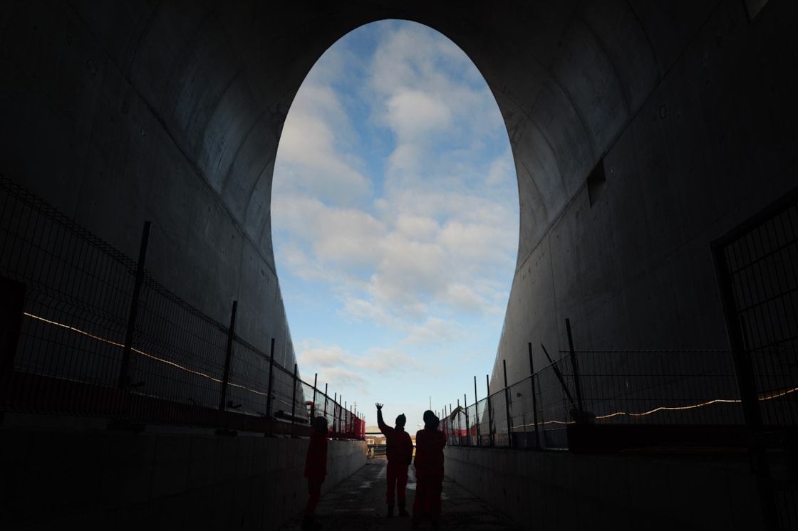 Two men stood against the backdrop of a tunnel entrance
