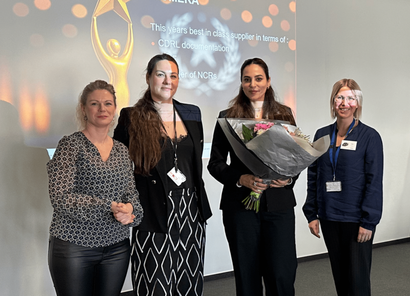 Image of 4 people at Supplier Awards, one them is holding some flowers