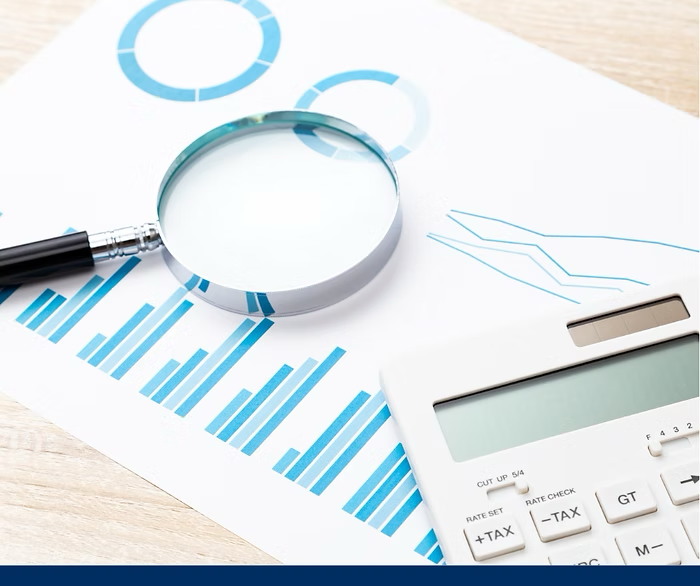 Magnifying Glass, calculator and paperwork on a table