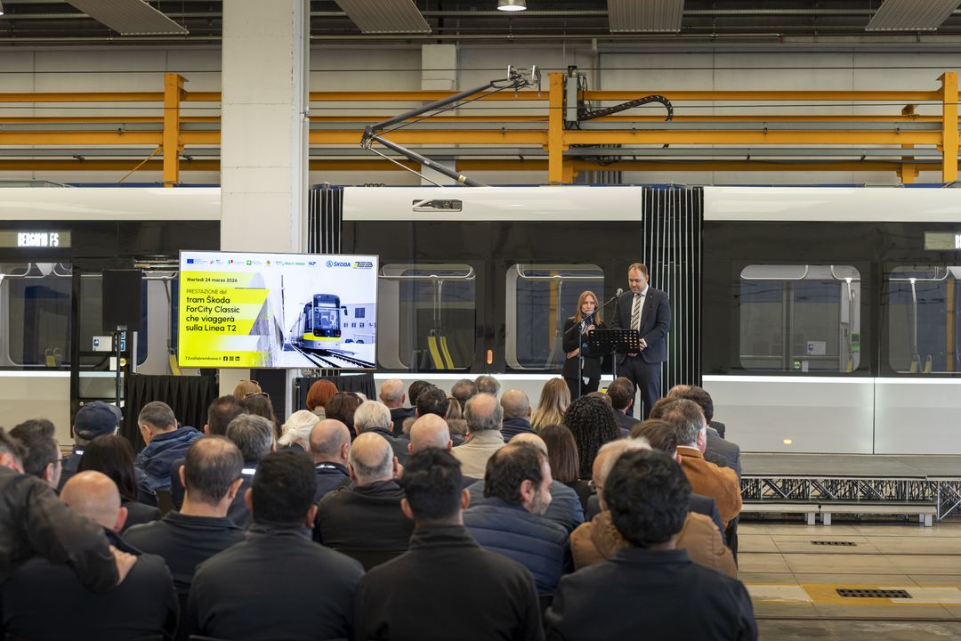 People stood in front of a presentation of a tram