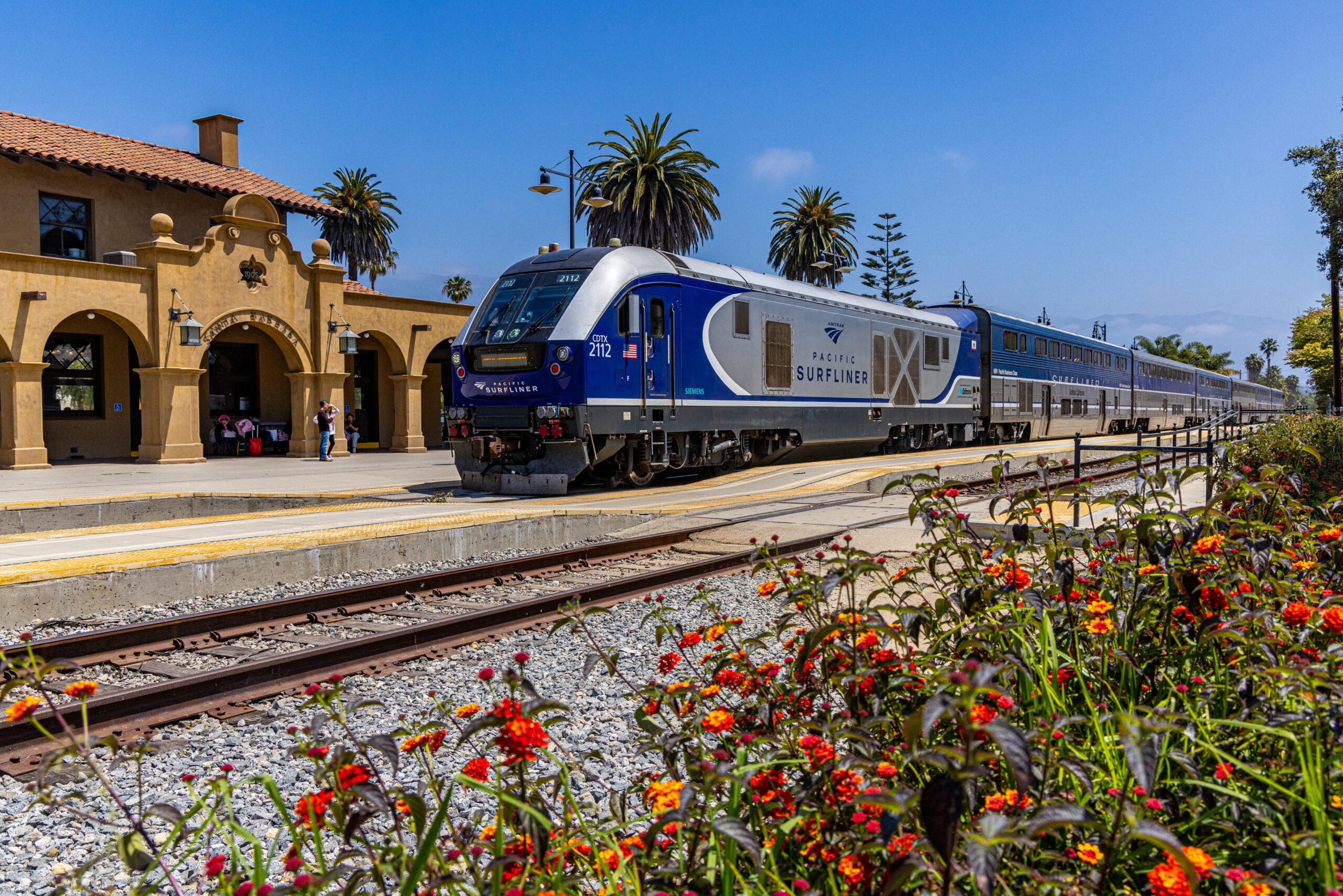 A train at a station in a sunny location