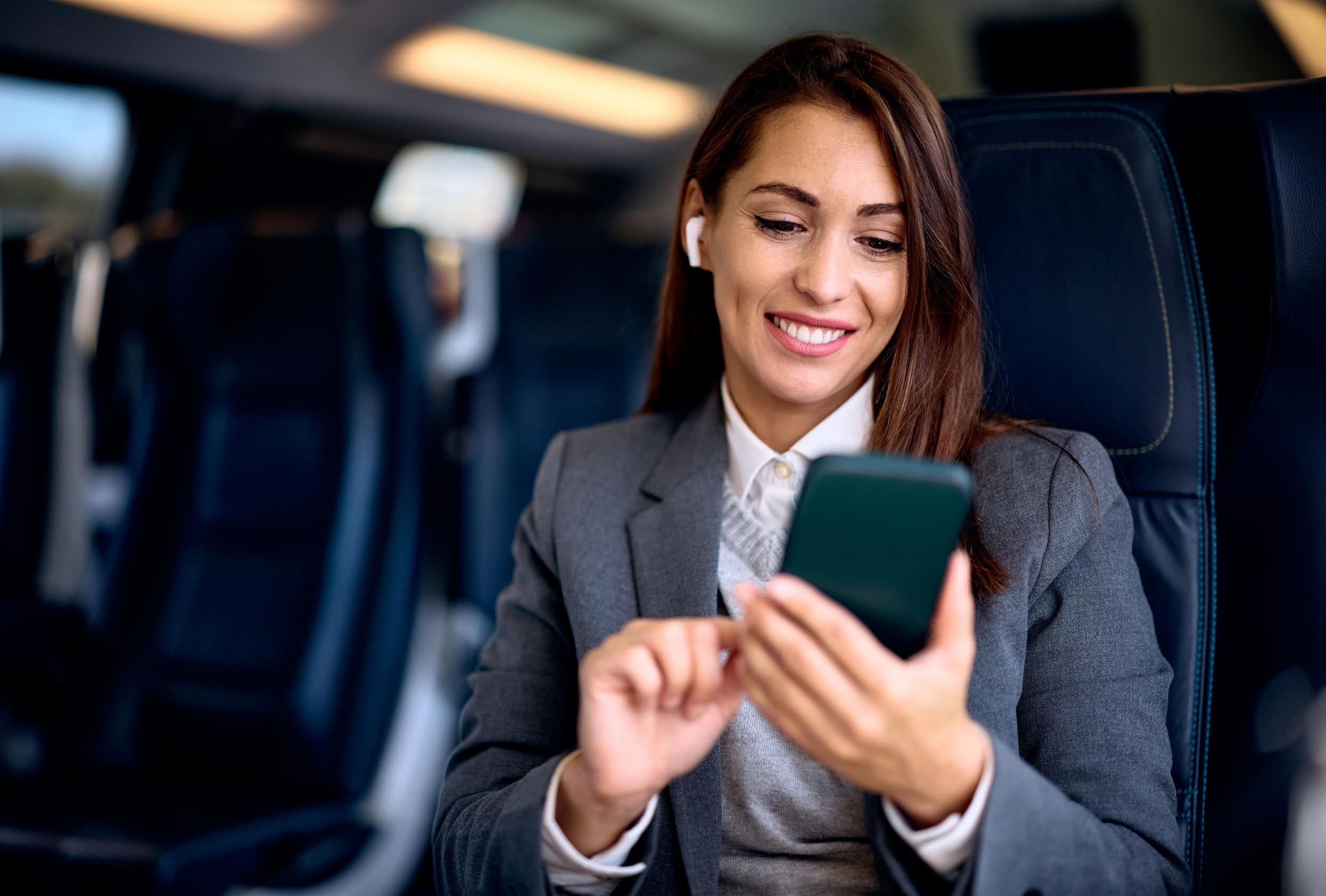 Stock image - woman on a train using her phone