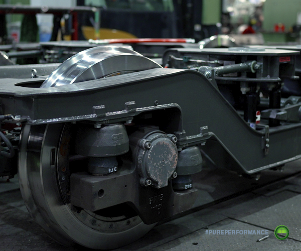 A bogie frame with wheelset in a rail workshop. Precision cleaning of components like these is essential before reassembly and return to service.