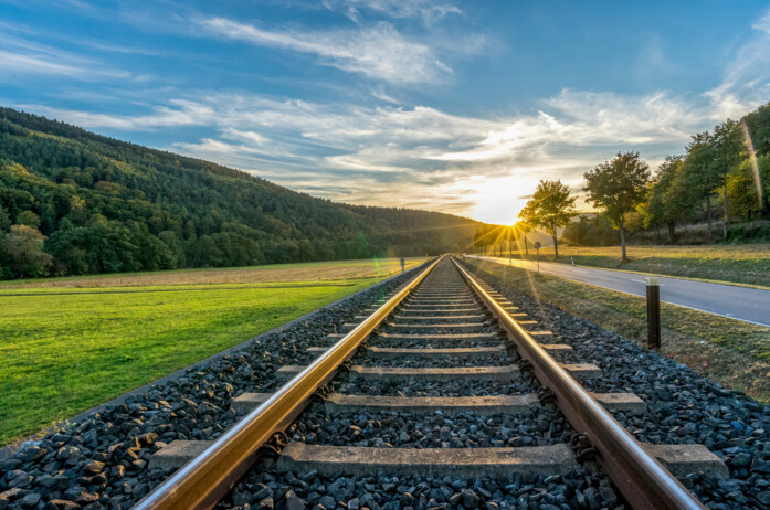 Railway track through open countryside at sunset