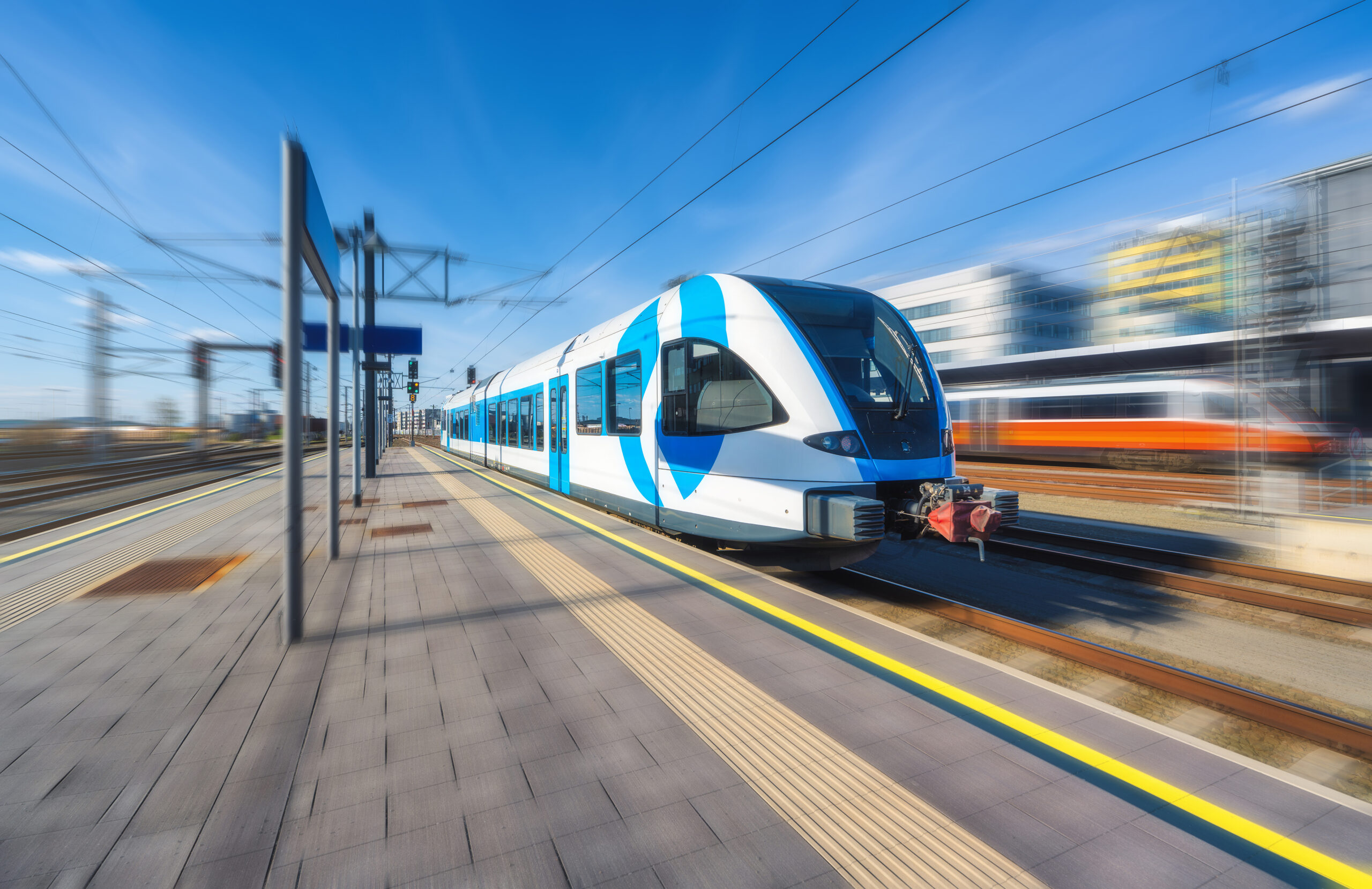 Modern light rail train departing a station platform, motion blur effect