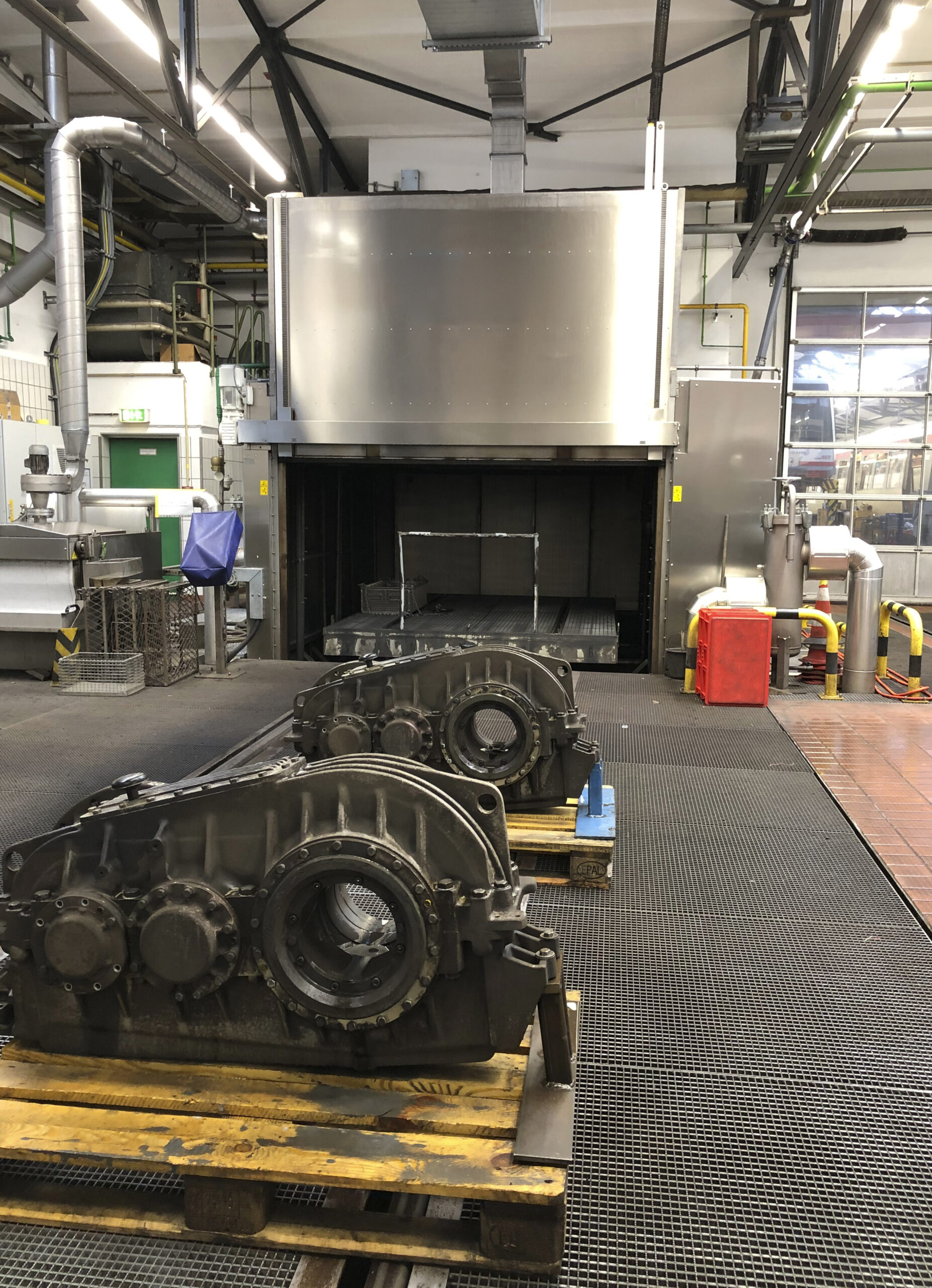 Bogie gearboxes on pallets in front of a cleaning oven at a Hamburger Hochbahn maintenance workshop