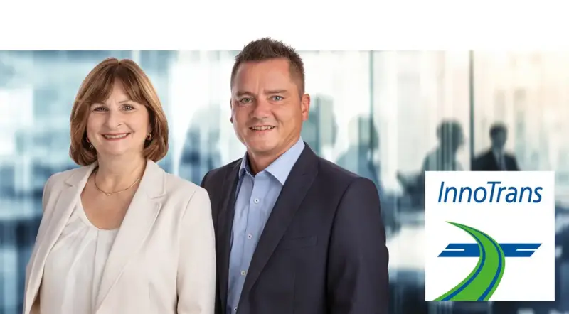 wo ASC Sensors representatives smiling for a promotional photo alongside the InnoTrans event logo.