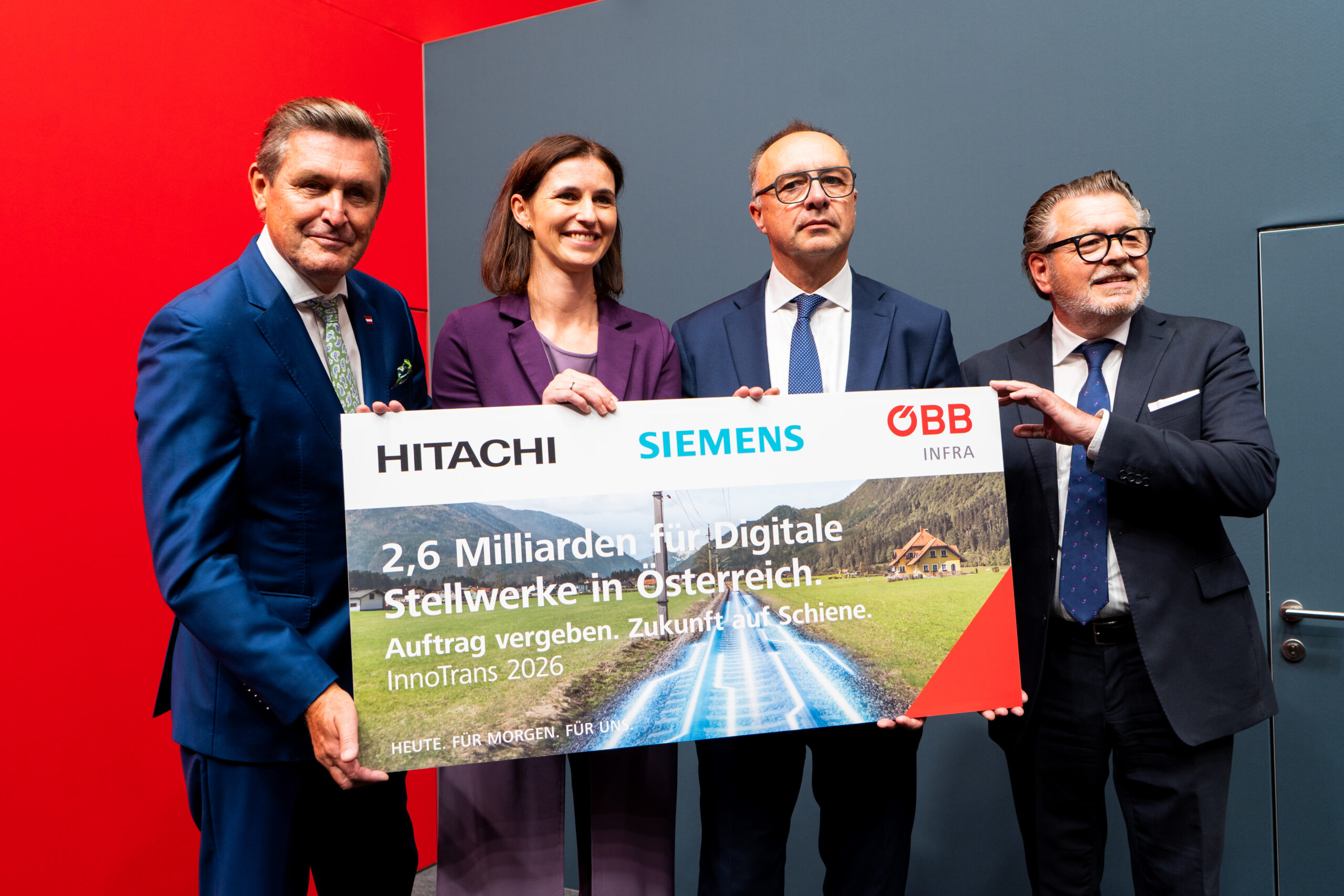 Members of Hitachi Rail & ÖBB holding a large photo at InnoTrans 2026