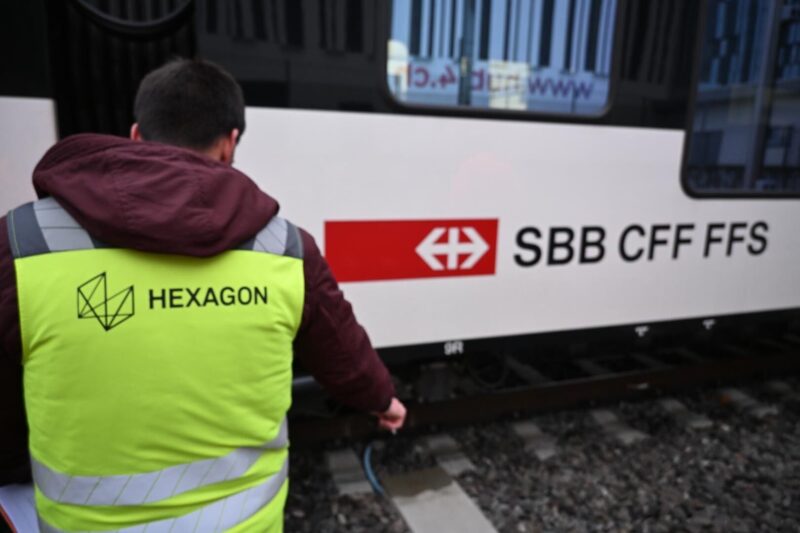 Hexagon engineer beside an SBB CFF FFS train carriage during wheelset measurement work