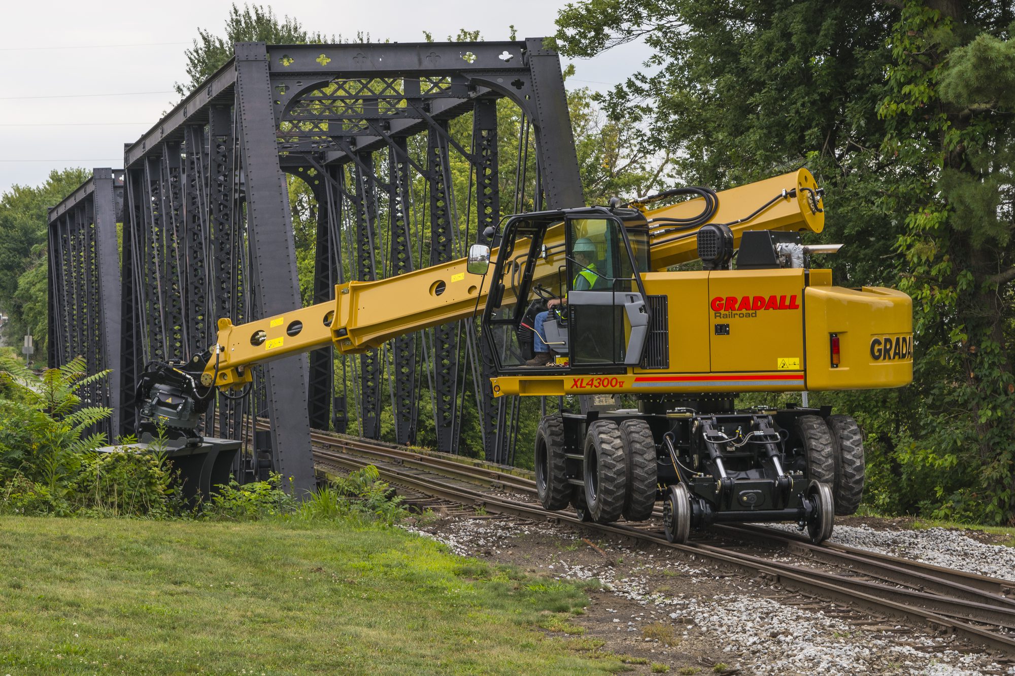 Gradall TrackStar XL 4330 V rough terrain road-rail excavator working beside a steel railway truss bridge
