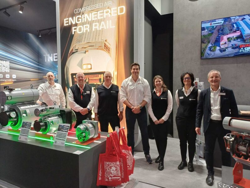 The Mattei Group team at its stand at InnoTrans 2026 in Berlin, alongside the RVR 03 and RVR 01 rotary vane compressors and, at right, a cutaway air end showing the machine’s inner workings.