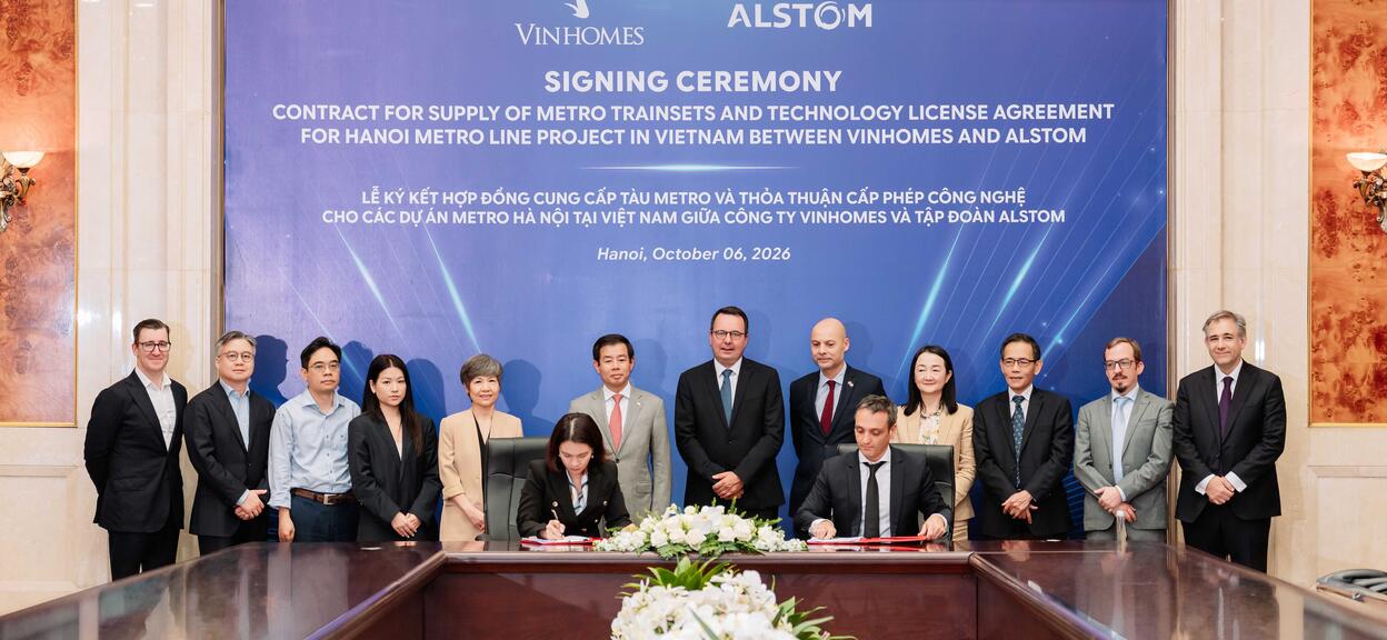 A group of people stood in front of a large announcement sign 