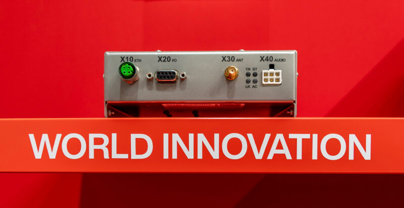 cn-mobility InnoCom® ELA to Auracast™ Gateway with Ethernet, I/O, antenna and audio ports on a red World Innovation display
