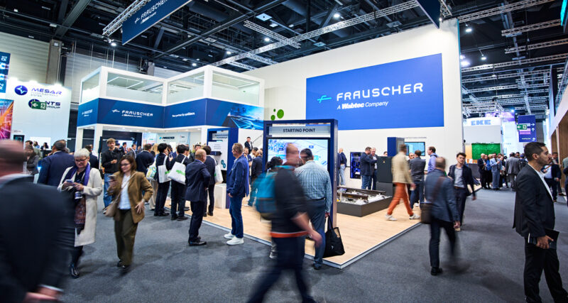 Visitors crowding the two-storey Frauscher stand, branded "A Wabtec Company", in Hall 27 at InnoTrans 2026
