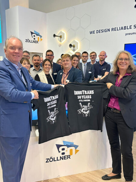 Zöllner team at its InnoTrans 2026 stand holding "InnoTrans 30 Years" T-shirts, marking 80 years of Zöllner and 30 years of InnoTrans
